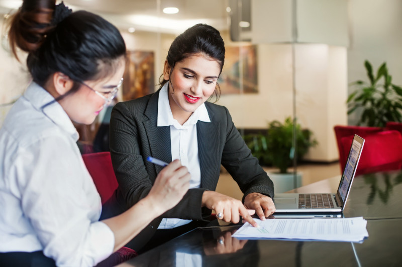 An agent and her client signing a document